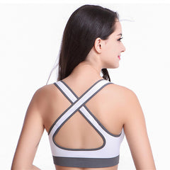 Woman wearing a white sports bra with gray straps on a white background