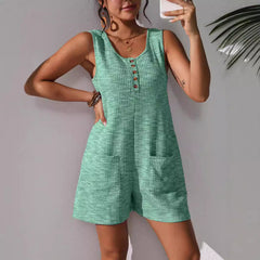 Sleeveless olive green utility vest jumpsuit featuring a button-down front bodice, structured collar, and deep patch pockets